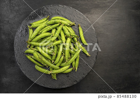 Top view Ripe pods of green peas on black background. Fresh vegetables. Legumes. 85488130