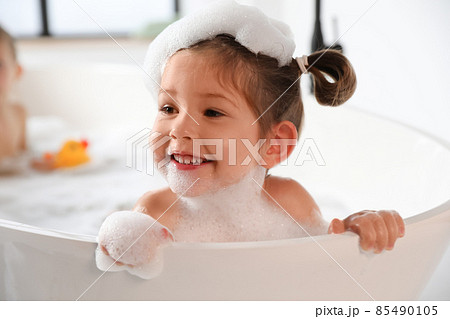 Cute little girl taking bubble bath at home 85490105