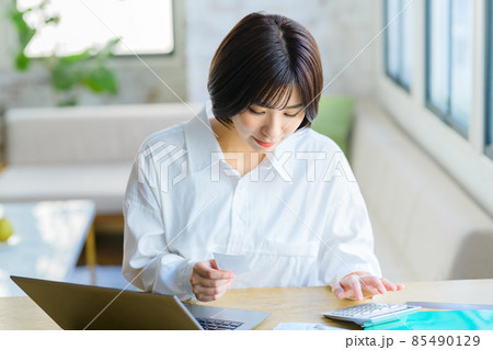 自宅でレシートを入力する若い主婦の確定申告イメージ 85490129