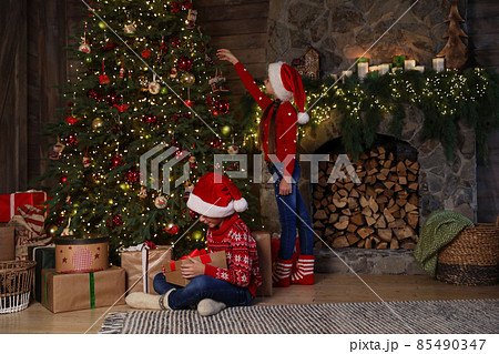 Children near beautiful Christmas tree at home Children near beautiful Christmas tree at home 85490347