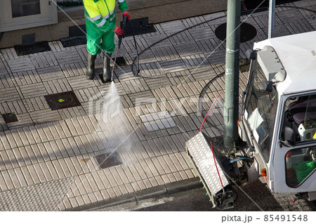 Sweeper washing a street sidewalk with high pressure water jet machine of a cleaning vehicle. Street maintenance Sweeper washing a street sidewalk with high pressure water jet machine of a cleaning vehicle. Street maintenance 85491548