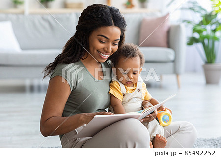 Caring African American Mommy Reading Book For Her Toddler Son At Home 85492252