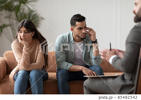 Sad couple sitting at therapy session in therapists office 85492542