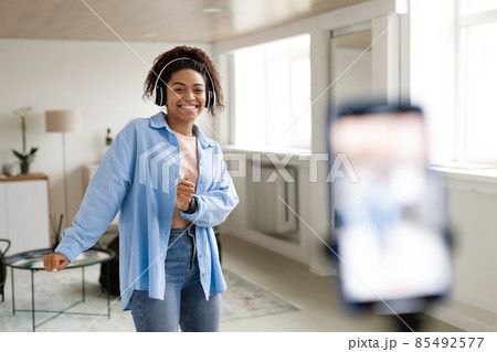 Cheerful black woman filming dance video on cellphone Cheerful black woman filming dance video on cellphone 85492577