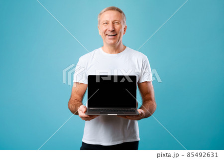 Happy mature man showing black empty pc screen 85492631