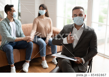 Happy couple reconciling at therapy session, therapists showing thumbs up Happy couple reconciling at therapy session, therapists showing thumbs up 85492867