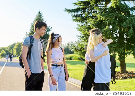 Meeting of smiling teenage friends in a sunny summer park 85493618