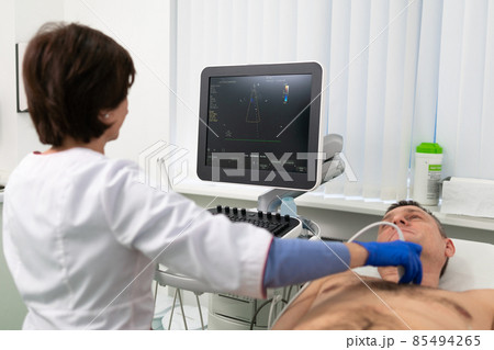 Doctor using ultrasound machine to scan heart of a male patient. Cardiologist makes a patient an echocardiographic test in a clinic. Patient under ultrasound examination in the hospital 85494265