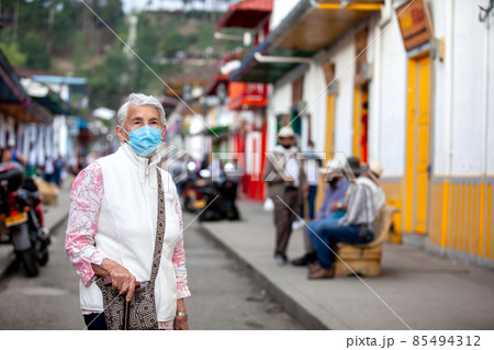 Senior woman at a traditional colorful street in the beautiful colonial town of Salento in the region of Quindio in Colombia 85494312