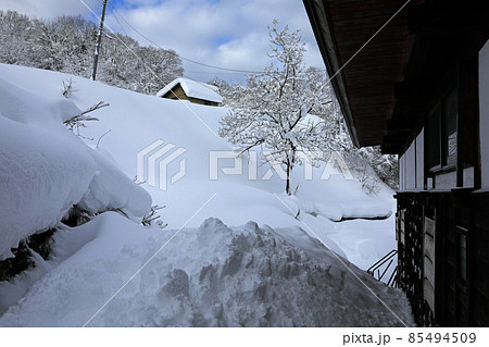 豪雪地の冬、古民家と小屋が雪に埋まる　福島県只見町 85494509