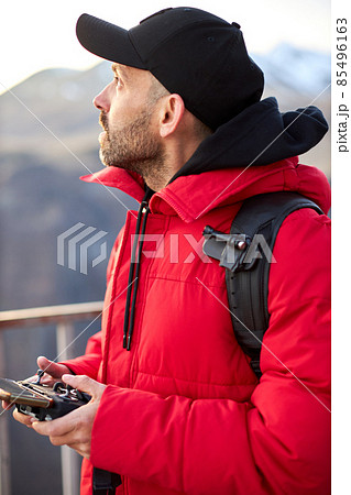 Tourist controls the drone from the remote control with a smartphone Tourist controls the drone from the remote control with a smartphone 85496163