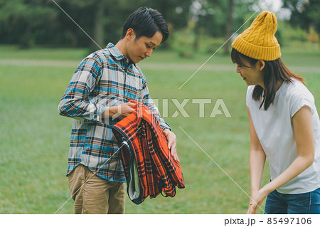 レジャーシートを畳むカップル 85497106