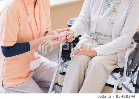 介護イメージ　車椅子に座るシニア女性と介護士の手元　撮影協力「LINK FOREST」 85498344