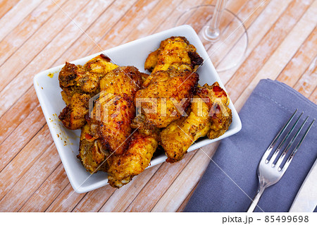 Appetizing baked chicken wings in plate closeup Appetizing baked chicken wings in plate closeup 85499698