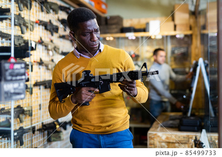 Portrait of african american man in gun shop showing rifle 85499733