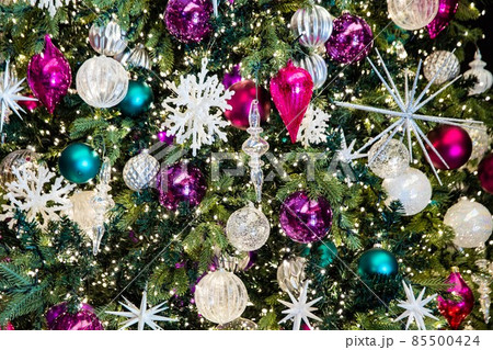Gorgeous green Christmas tree and decorations glittering in golden, silver, purple, red and white colors 85500424
