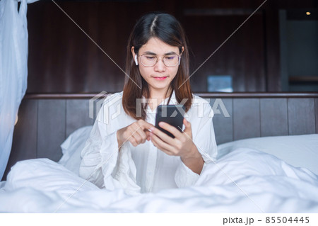 Happy woman using smart phone for video call, female meeting  online by mobile phone on bed. technology, network, work from home, lifestyle and digital communication concept 85504445
