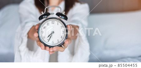 Woman holding alarm clock on bed, happy female wake up in the morning. daily routine, sleep, relaxing and have a nice day concepts Woman holding alarm clock on bed, happy female wake up in the morning. daily routine, sleep, relaxing and have a nice day concepts 85504455