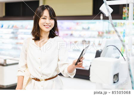 スーパーでスマホ決済を使う若い女性 スーパーでスマホ決済を使う若い女性 85505068