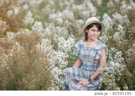 Happy woman tourist in blue dress enjoy in white Margaret flowers garden. travel, nature, vacation and holiday concept 85505195