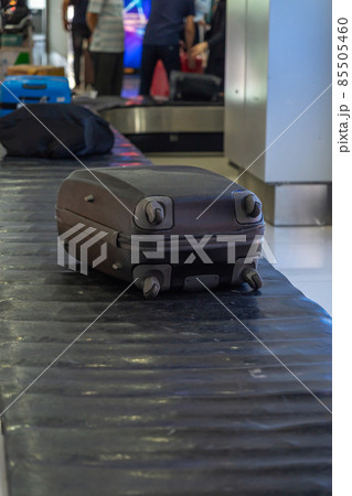 Vertical photo of suitcase on luggage conveyor belt 85505460