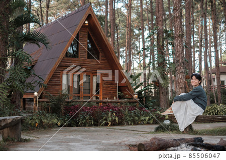 Happy woman in sweater traveling in pine tree forest, tourist visit at Doi Bo Luang, Chiang Mai, Thailand, Landmark and popular for tourist attractions. Vacation and journey concept 85506047