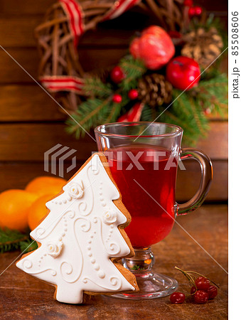 a cup of tea with spices and viburnum berries and Christmas gingerbread with a wreath of evergreen branches a cup of tea with spices and viburnum berries and Christmas gingerbread with a wreath of evergreen branches 85508606