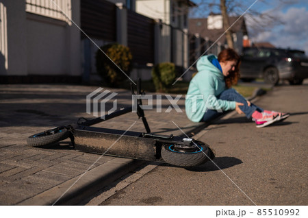 A Caucasian woman fell from an electric scooter and injured her leg. Suffering from pain. 85510992