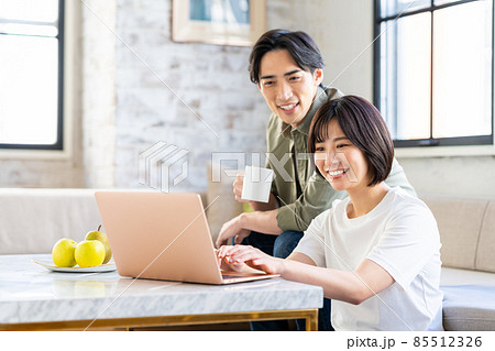 パソコンを見る若い夫婦 85512326