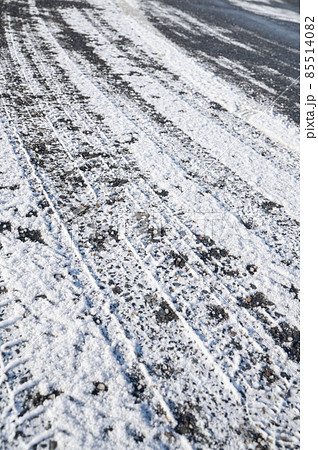 タイヤ跡が残る積雪した道路 85514082