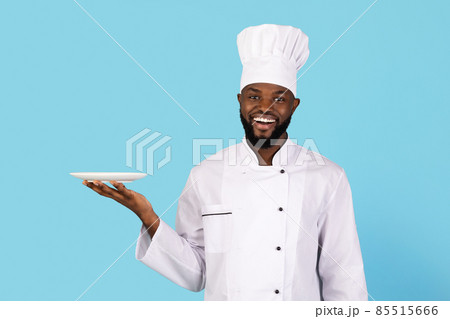 Portrait Of Smiling Young Black Chef In Uniform Holding Empty Plate Portrait Of Smiling Young Black Chef In Uniform Holding Empty Plate 85515666