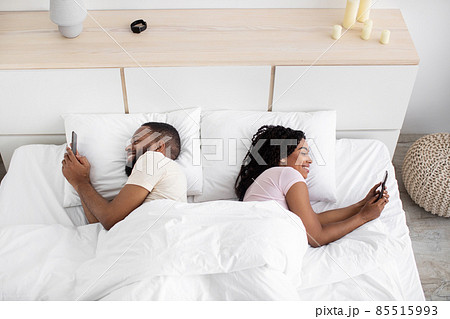 Cheerful glad young black lady and guy suffer from addiction to phone, social networks and online games 85515993