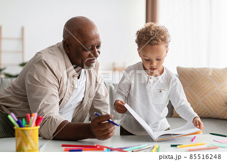 African American Little Boy Showing Drawings To Grandpa At Home African American Little Boy Showing Drawings To Grandpa At Home 85516248