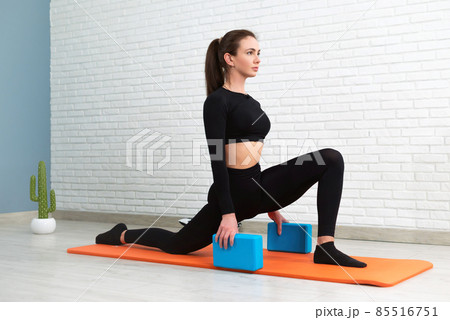 the girl conducts a workout to stretch her body and sit on the splits the girl conducts a workout to stretch her body and sit on the splits 85516751