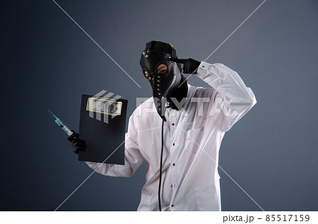 doctor in a dressing gown, in a plague doctor's mask, is vaccinating doctor in a dressing gown, in a plague doctor's mask, is vaccinating 85517159