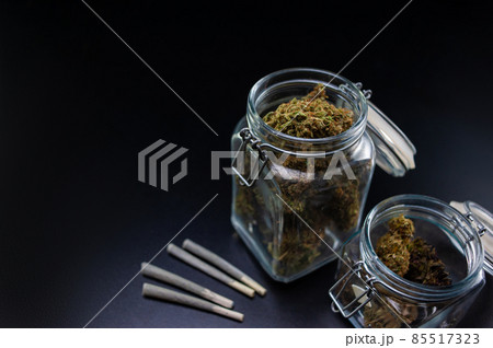 Dry marijuana in a jar and jambs 85517323
