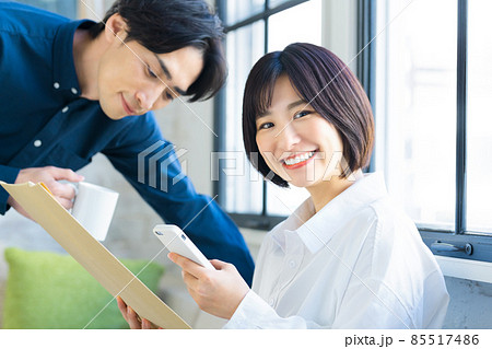 スマホを見ながら荷物を確認する若いカップル 85517486