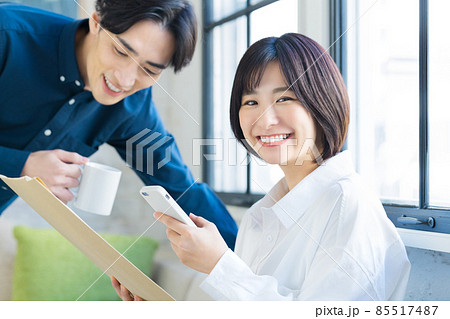 スマホを見ながら荷物を確認する若いカップル スマホを見ながら荷物を確認する若いカップル 85517487