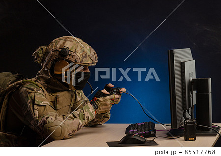 soldier sitting at a computer is conducting a cyber war 85517768