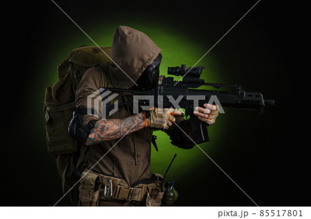 man Stalker with a gun with a telescopic sight and a backpack in a gas mask on a dark background with emotions looking, aiming, watching, sneaking man Stalker with a gun with a telescopic sight and a backpack in a gas mask on a dark background with emotions looking, aiming, watching, sneaking 85517801