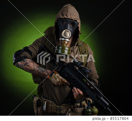 man Stalker with a gun with a telescopic sight and a backpack in a gas mask on a dark background with emotions looking, aiming, watching, sneaking man Stalker with a gun with a telescopic sight and a backpack in a gas mask on a dark background with emotions looking, aiming, watching, sneaking 85517804