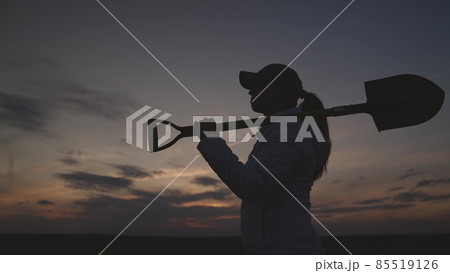 silhouette of a senior farmer with a shovel at sunset, farming, small business of a gardener, the concept of an american work on plantation, an agronomist in a rural land of the land goes to dig soil 85519126