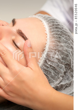 Face massage of detox therapy for the pretty female patient at spa salon. 85520646