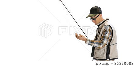 Portrait of young man, professional fisherman with fishing rod, spinning and equipment going to river isolated over white studio background 85520688