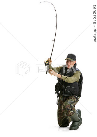 Portrait of young man, professional fisherman with fishing rod, spinning and equipment sitting isolated over white studio background Portrait of young man, professional fisherman with fishing rod, spinning and equipment sitting isolated over white studio background 85520691