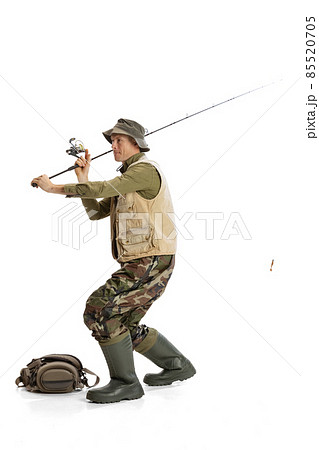 Portrait of young man, professional fishman with fishing rod, spinning and equipment going to river isolated over white studio background 85520705