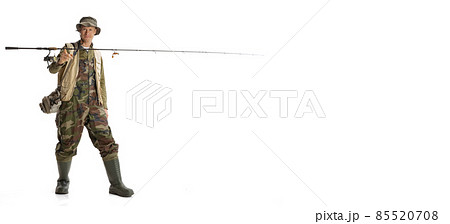 Portrait of young man, professional fisherman with fishing rod, spinning and equipment going to river isolated over white studio background Portrait of young man, professional fisherman with fishing rod, spinning and equipment going to river isolated over white studio background 85520708