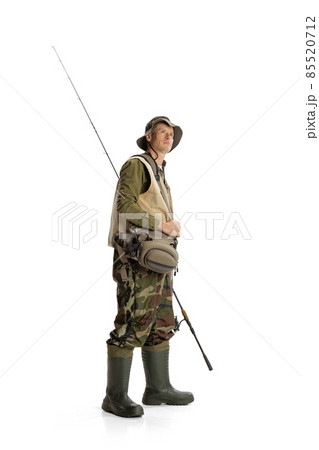 Portrait of young man, professional fishman with fishing rod, spinning and equipment going to river isolated over white studio background Portrait of young man, professional fishman with fishing rod, spinning and equipment going to river isolated over white studio background 85520712