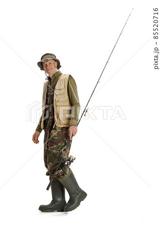 Portrait of young man, professional fishman with fishing rod, spinning and equipment going to river isolated over white studio background 85520716