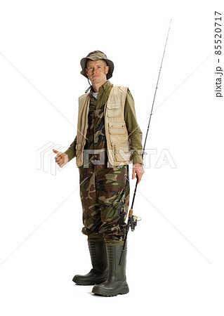 Portrait of young man, professional fisherman with fishing rod, spinning and equipment going to river isolated over white studio background Portrait of young man, professional fisherman with fishing rod, spinning and equipment going to river isolated over white studio background 85520717